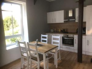 a kitchen with a wooden table and chairs and a stove at Ferienwohnung Storchennest in Drochtersen