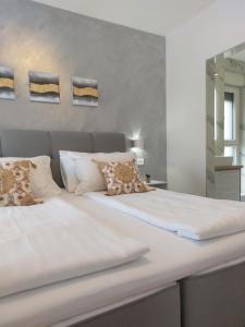 een bed met witte lakens en kussens in een kamer bij Villa Crystal Aenona in Nin