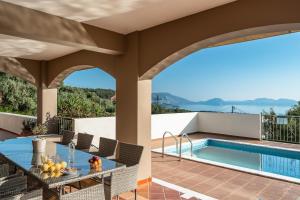 a house with a swimming pool and a patio at Kumusha Villa near Fiscardo in Mánganos