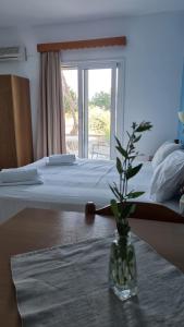 a vase with a plant on a table in a bedroom at Studios Nina in Amoopi