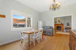 a dining room with a table and chairs and a refrigerator at Central Heritage Villa in Rotorua