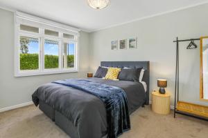 a bedroom with a bed and a window at Central Heritage Villa in Rotorua