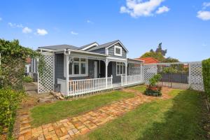 a house with a white fence and a yard at Central Heritage Villa in Rotorua