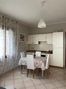 een keuken met een tafel en stoelen en een eetkamer bij La Rosa del Garda in Peschiera del Garda