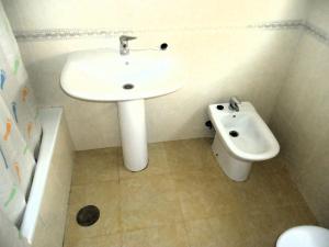 a white bathroom with a sink and a toilet at Mediterraneo LEK in Peñíscola +12 photos