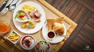 dois pratos de comida para o pequeno-almoço numa mesa de madeira em Daiwa Roynet Hotel Koriyama Ekimae em Koriyama