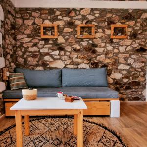 a living room with a blue couch and a table at Votsalo Cozy Apartments in Limenaria