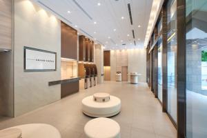 a lobby with a waiting area with stools and a table at Sotetsu Grand Fresa Saigon 相鉄グランドフレッサ サイゴン in Ho Chi Minh City