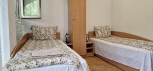 1 dormitorio con 2 camas y ventana en Guest House Selin, en Veliko Tŭrnovo