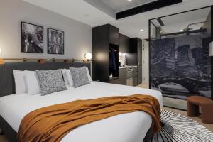 a bedroom with a large bed with a brown blanket on it at Veriu Collingwood in Melbourne