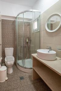 a bathroom with a shower and a toilet and a sink at Fantastic Matala 2 in Matala