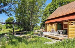 a log cabin with a deck and a table and chairs at Amazing Apartment In Vedum With Kitchen in Vedum