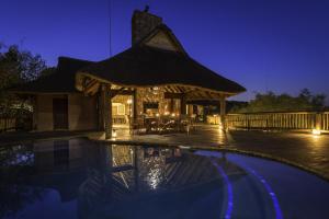 un resort con piscina e gazebo di notte di Tshwene Lodge a Riserva Naturale di Welgevonden