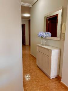 un pasillo con un jarrón de flores azules en un armario en Vista a Quenxe, en Corcubión