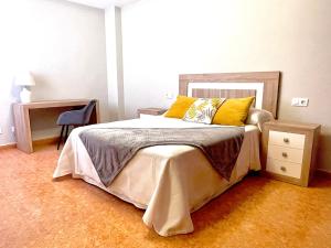 Un dormitorio con una cama con almohadas amarillas. en Vista a Quenxe, en Corcubión