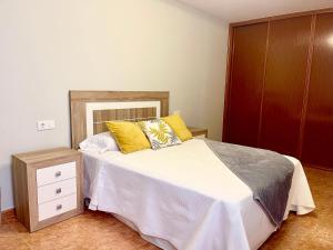 1 dormitorio con 1 cama y armario de madera en Vista a Quenxe, en Corcubión