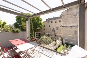 a balcony with a table and chairs and a view of a castle at Appartement moderne 3 chb 3 sdb climatisé in Avignon