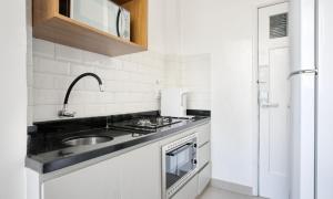 a white kitchen with a sink and a stove at Tabas Lindo apê 2 quartos em Copacabana CP0005 in Rio de Janeiro