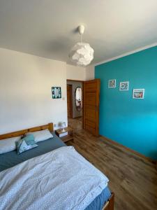 a bedroom with a bed and a blue wall at Apartament wakacyjny Chałupy in Chałupy