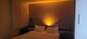 a bedroom with a bed with a light on the wall at BLUE SKY in Bet HaKerem