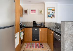 a small kitchen with a sink and a refrigerator at At Forest Stay in Margaret River Town