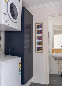 uma casa de banho com uma máquina de lavar roupa na parede em At Forest Stay em Margaret River Town