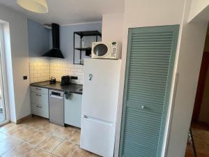 a kitchen with a refrigerator and a microwave on top of it at Apartament wakacyjny Chałupy in Chałupy