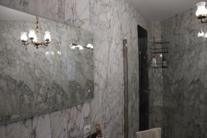 a bathroom with a large mirror and a shower at Il Giardino della Scuncerta in Lecce
