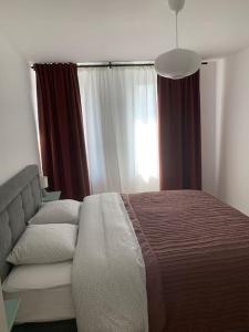 um quarto com uma cama, um sofá e uma janela em Appartement au centre d'une ville historique. em Bastogne