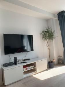 een wit entertainmentcentrum met een flatscreen-tv bij Appartement au centre d'une ville historique. in Bastenaken