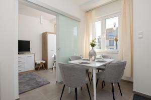 a dining room with a white table and chairs at Słoneczna Apartment Mielno Unieście by Renters in Mielno