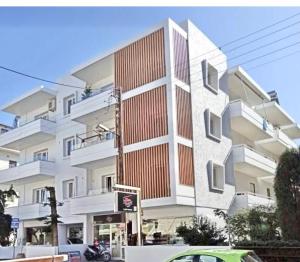 a tall white building with a car parked in front of it at Kondylaki Apartments in Heraklio