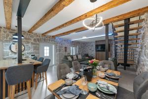 a dining room and living room with a stone wall at Villa Green Garden in Hreljin