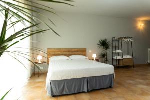 um quarto com uma cama branca e uma planta em LPH - Dannunziano Country House em Chieti