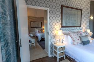 Mariner Guesthouse & Villa في سيمونز تاون: غرفة نوم مع سرير وغرفة معيشة