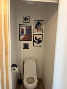 uma casa de banho com um WC com fotografias na parede em Chez Mimi, la route des fruits em Jumièges