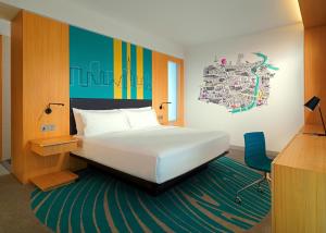 a bedroom with a bed and a desk and a chair at Aloft Dubai Creek in Dubai