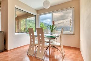 a dining room with a table and chairs and a window at Guest House Jovana in Kotor