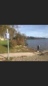 un hombre parado en la orilla de un cuerpo de agua en One Bedroom Rural Cottage with Hot tub, en Whitegate