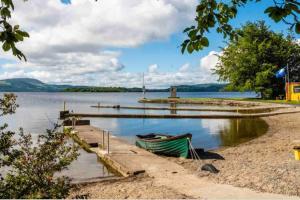 ein kleines Boot am Ufer eines Sees in der Unterkunft One Bedroom Rural Cottage with Hot tub in Whitegate