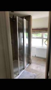 a hallway with a glass door in a room at One Bedroom Rural Cottage with Hot tub in Whitegate