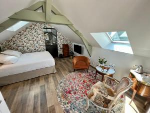 een slaapkamer met een bed en een tafel en stoelen bij Cave Auger La Maison d'Hôtes in Restigné