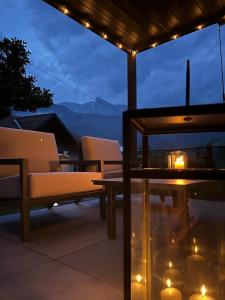 patio z 2 krzesłami i stołem z lampkami w obiekcie Cosy cottage with views near Kobarid w mieście Kobarid