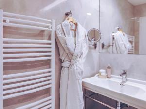 a robe hanging on a rack next to a sink at Aparthotel AMMI Nice Lafayette in Nice