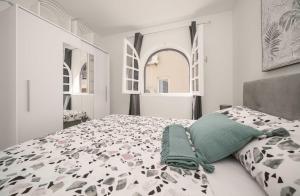 sypialnia z łóżkiem z czarno-białą kołdrą w obiekcie Vila MS w mieście Tribunj