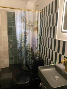 een badkamer met een douchegordijn, een toilet en een wastafel bij Schöne Wohnung mit Elbblick in Blankenese Strandlage in Hamburg