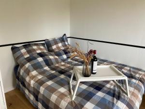 Una cama con una mesa con una botella de vino. en Schöne Wohnung mit Elbblick in Blankenese Strandlage, en Hamburgo