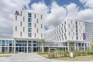 a large white building in front of a building at Premier Inn Wolfsburg City Centre in Wolfsburg