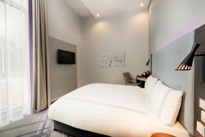 a bedroom with a white bed and a window at Premier Inn Wolfsburg City Centre in Wolfsburg