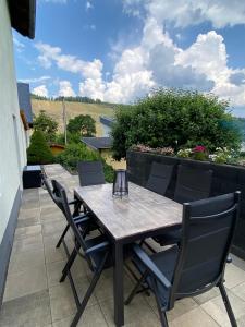 a wooden table and chairs on a patio at FeWo Sonnenlay - Apartments an der Mosel in Brauneberg